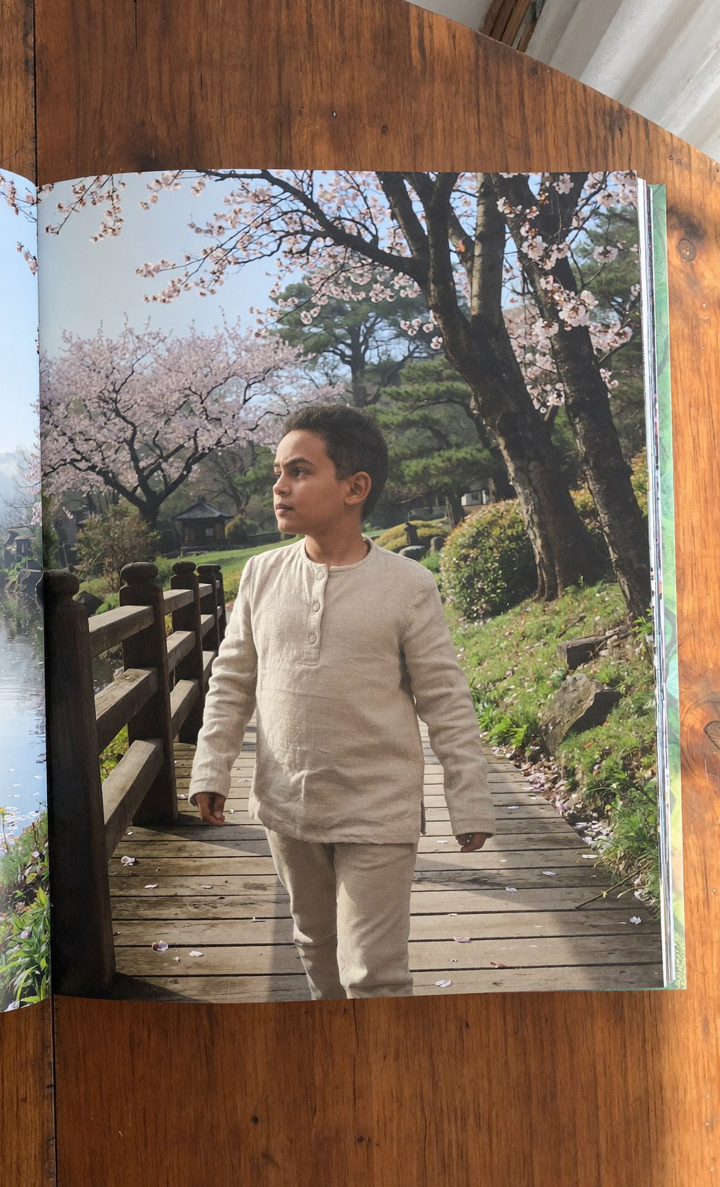 Page de droite du livre Storylunia : le meme enfant traversant un pont en bois dans un jardin japonais en fleurs de cerisier