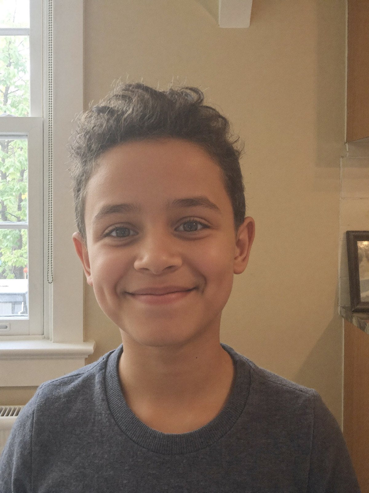 Photo iPhone d'un enfant souriant devant une fenetre