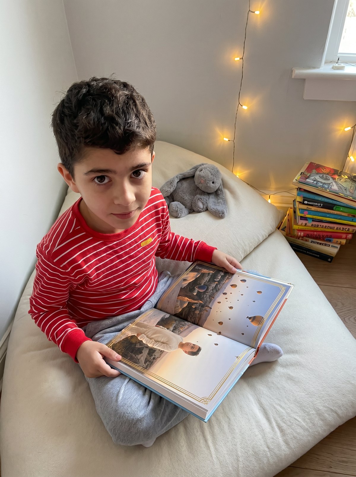 Un petit garcon lit son livre Storylunia dans son coin lecture